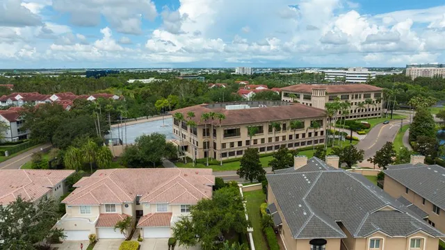 a view of a big house with a big yard plants and large trees