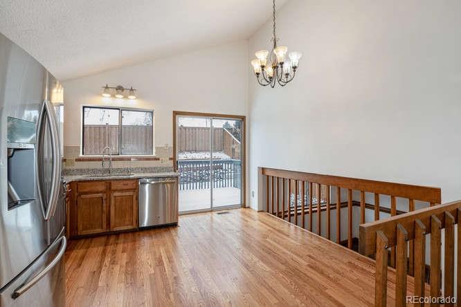 567 James Street Highlands Ranch, CO 80126 - Photo 6 of 17 a view of a kitchen with a sink wooden floor and chandelier