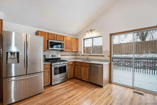 567 James Street Highlands Ranch, CO 80126 - Photo 7 of 17 a kitchen with stainless steel appliances granite countertop a refrigerator a stove a sink and a microwave