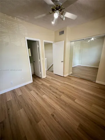 an empty room with wooden floor and entryway