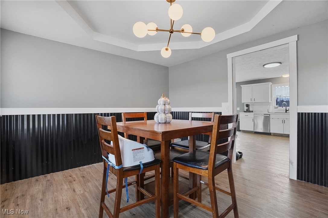 9278 Bryant Road Windham, OH 44288 - Photo 19 of 47 Dining space with a tray ceiling, light wood-style floors, and a chandelier