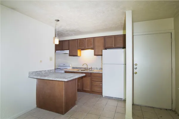 a kitchen with a sink a refrigerator and a stove