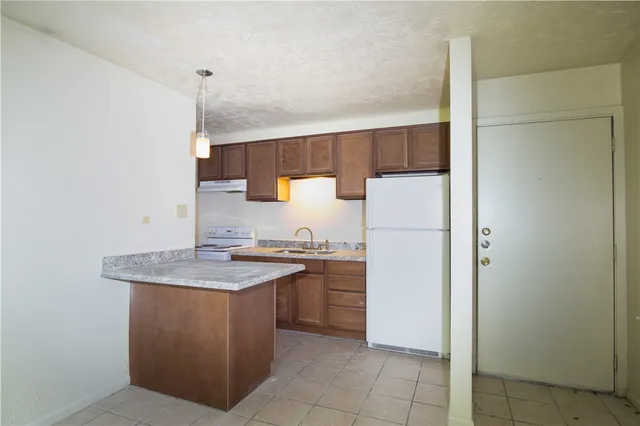 a kitchen with a sink a refrigerator and a stove
