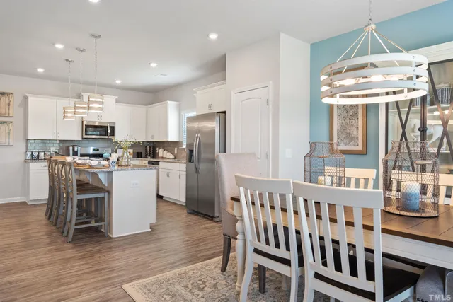 a kitchen with a table chairs refrigerator and microwave