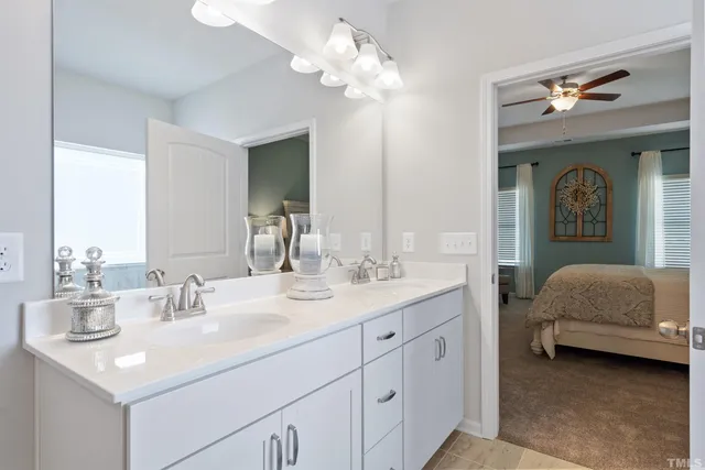 a en suite bathroom with a double vanity sink and a mirror