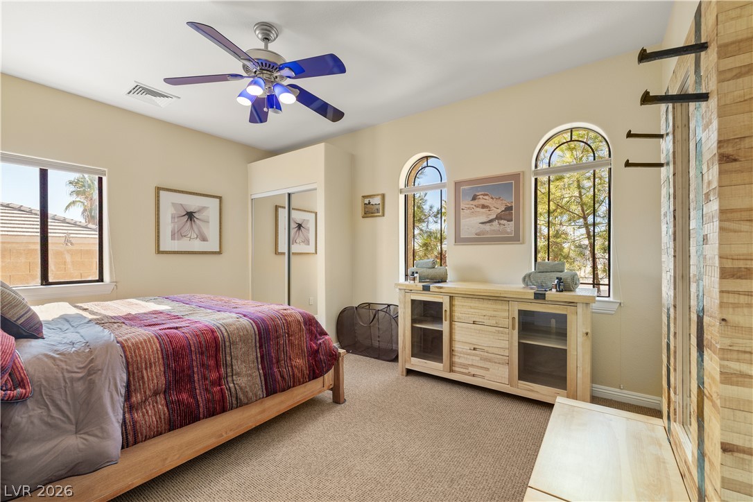 2181 Winery Road Pahrump, NV 89048 - Photo 41 of 52 Natural light streams into this bedroom through gracefully arched windows, illuminating a serene and comfortable space. Secondary bedroom in the Guest Wing quarters.