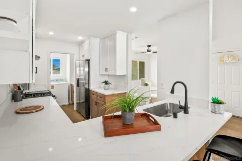 a kitchen with kitchen island a counter top a stove and cabinets