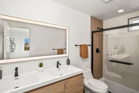 a bathroom with a sink a toilet and shower