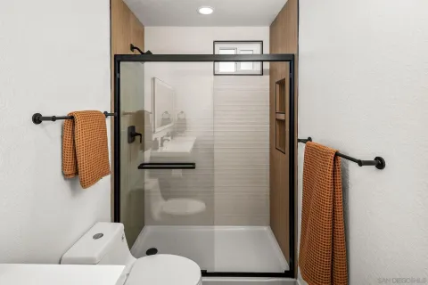 a bathroom with a shower toilet and a window