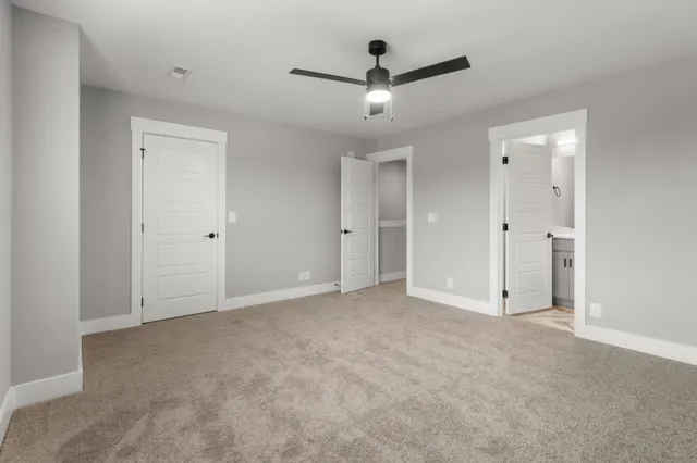 an empty room with windows and ceiling fan