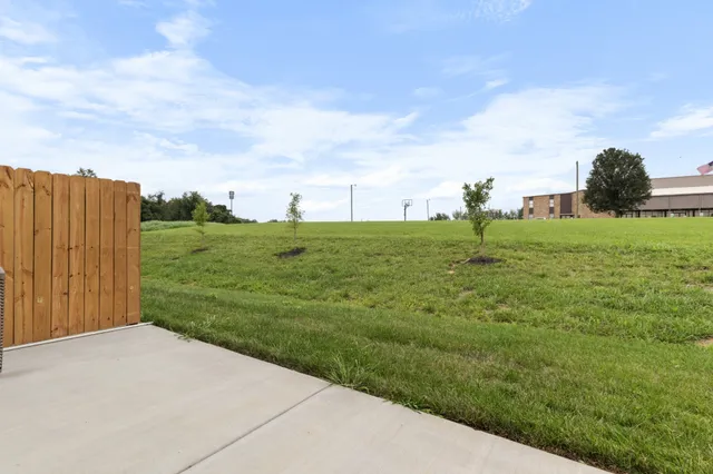 a kitchen with stainless steel appliances granite countertop a refrigerator a oven a sink and a dining table with wooden floor