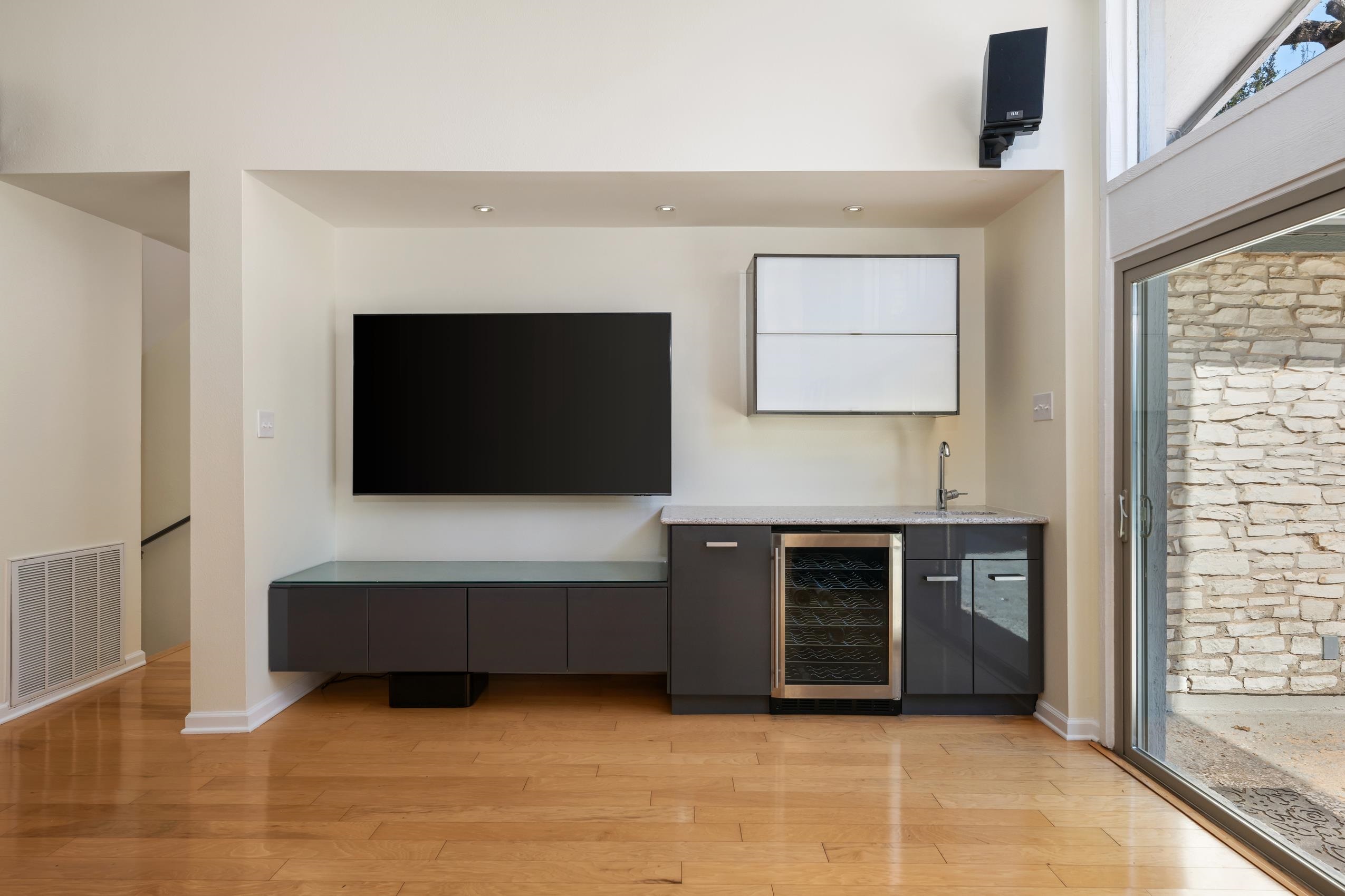 8805 Mountain Ridge Drive Austin, TX 78759 - Photo 12 of 30 a living room with furniture a flat screen tv and a fireplace