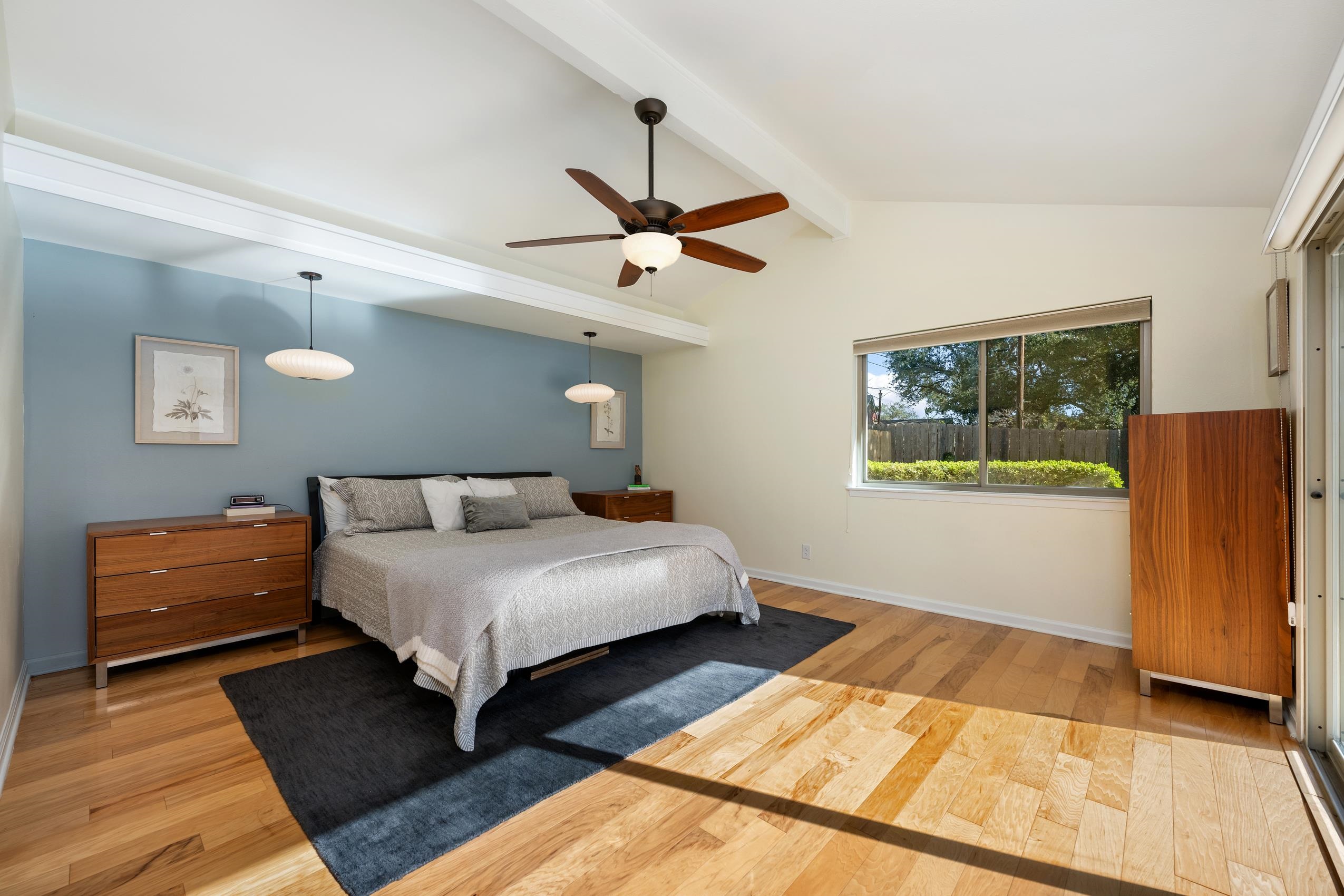 8805 Mountain Ridge Drive Austin, TX 78759 - Photo 15 of 30 a bedroom with bed and wooden floor