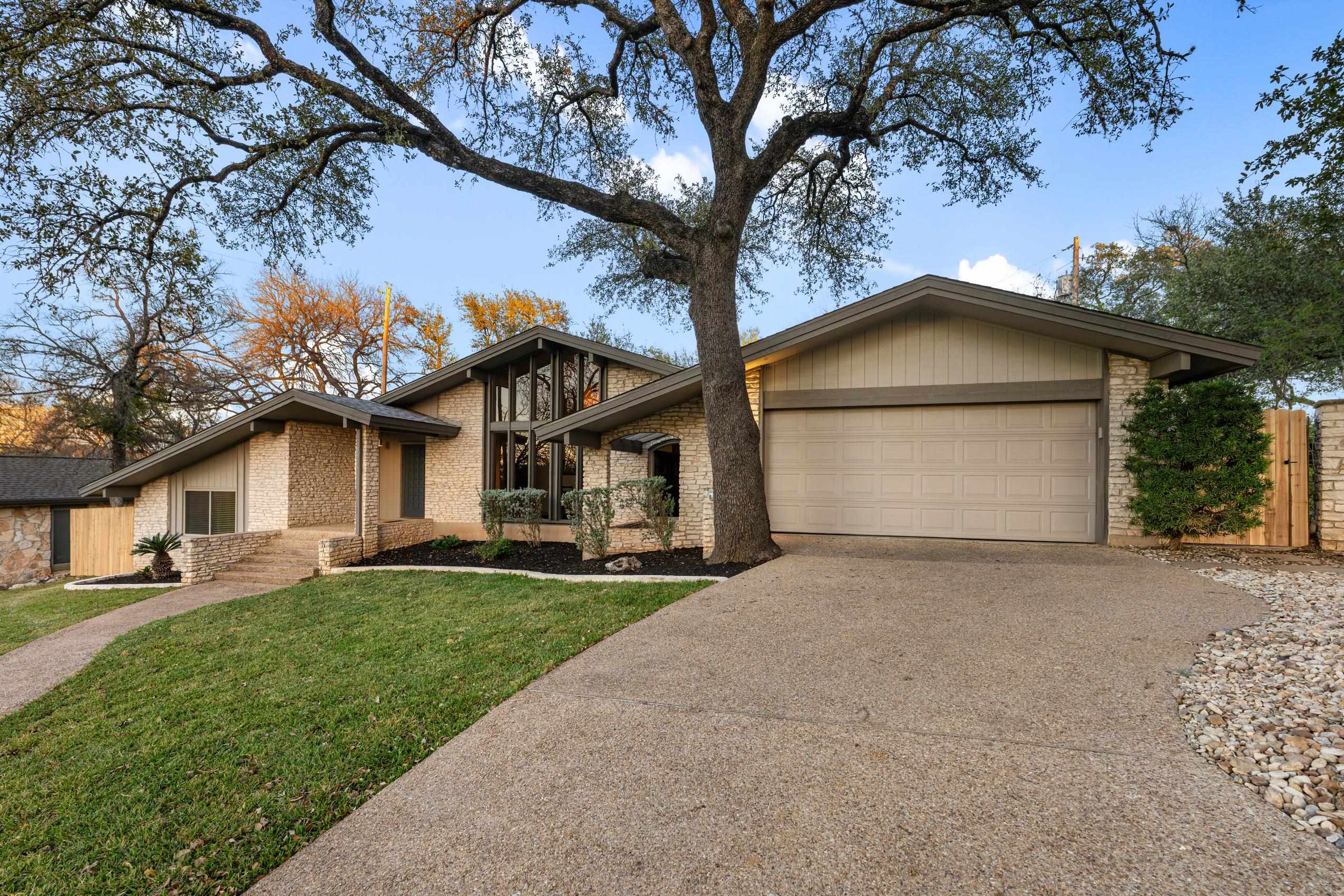 8805 Mountain Ridge Drive Austin, TX 78759 - Photo 2 of 30 a white house that has a tree in front of it