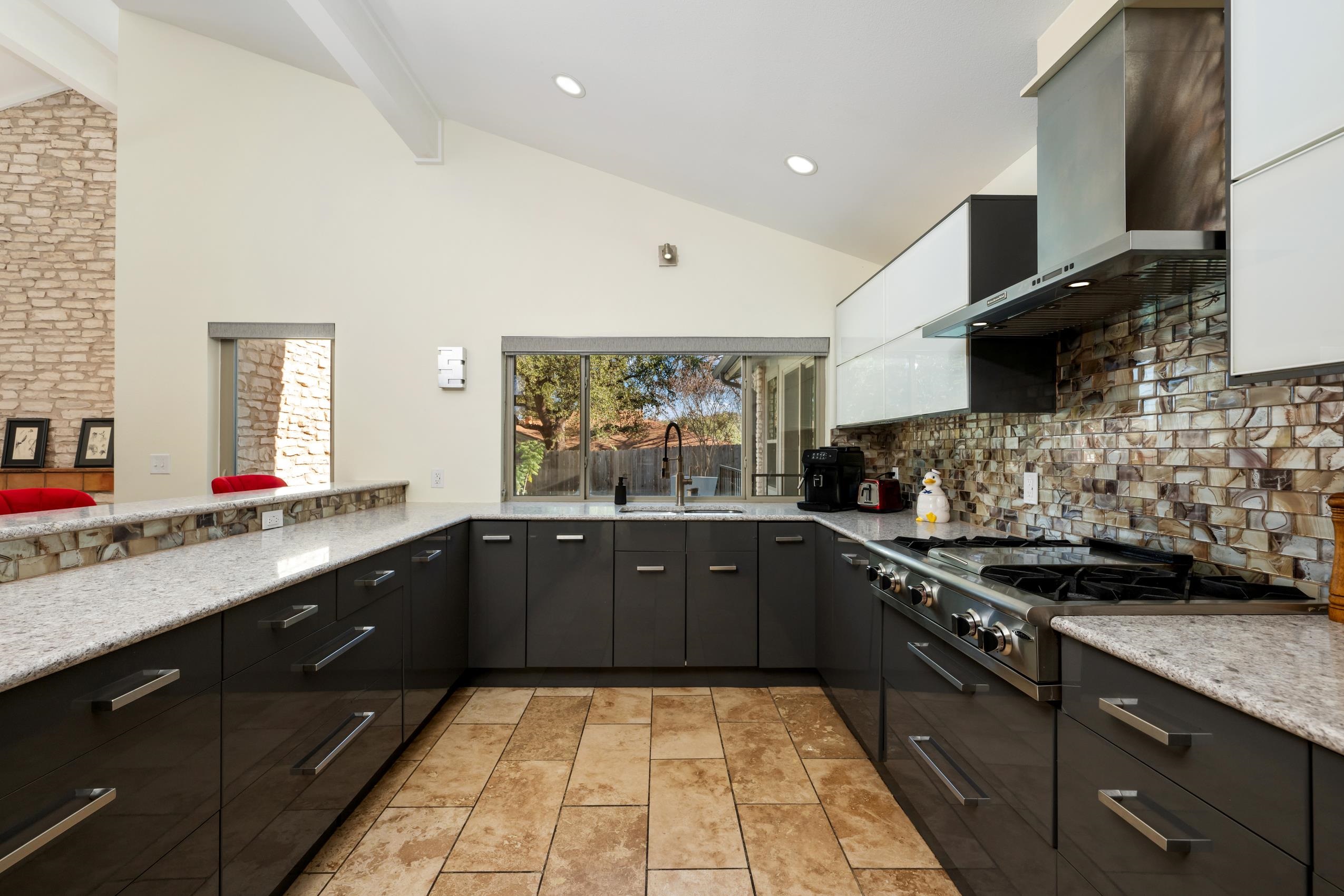 8805 Mountain Ridge Drive Austin, TX 78759 - Photo 10 of 30 a large kitchen with stainless steel appliances granite countertop a sink and cabinets
