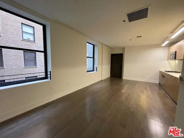 a view of a livingroom with an empty space and a window