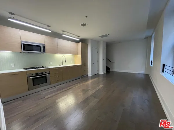 a kitchen with stainless steel appliances a stove and a wooden floor