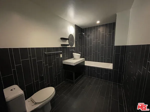 a bathroom with a sink toilet a mirror and shower