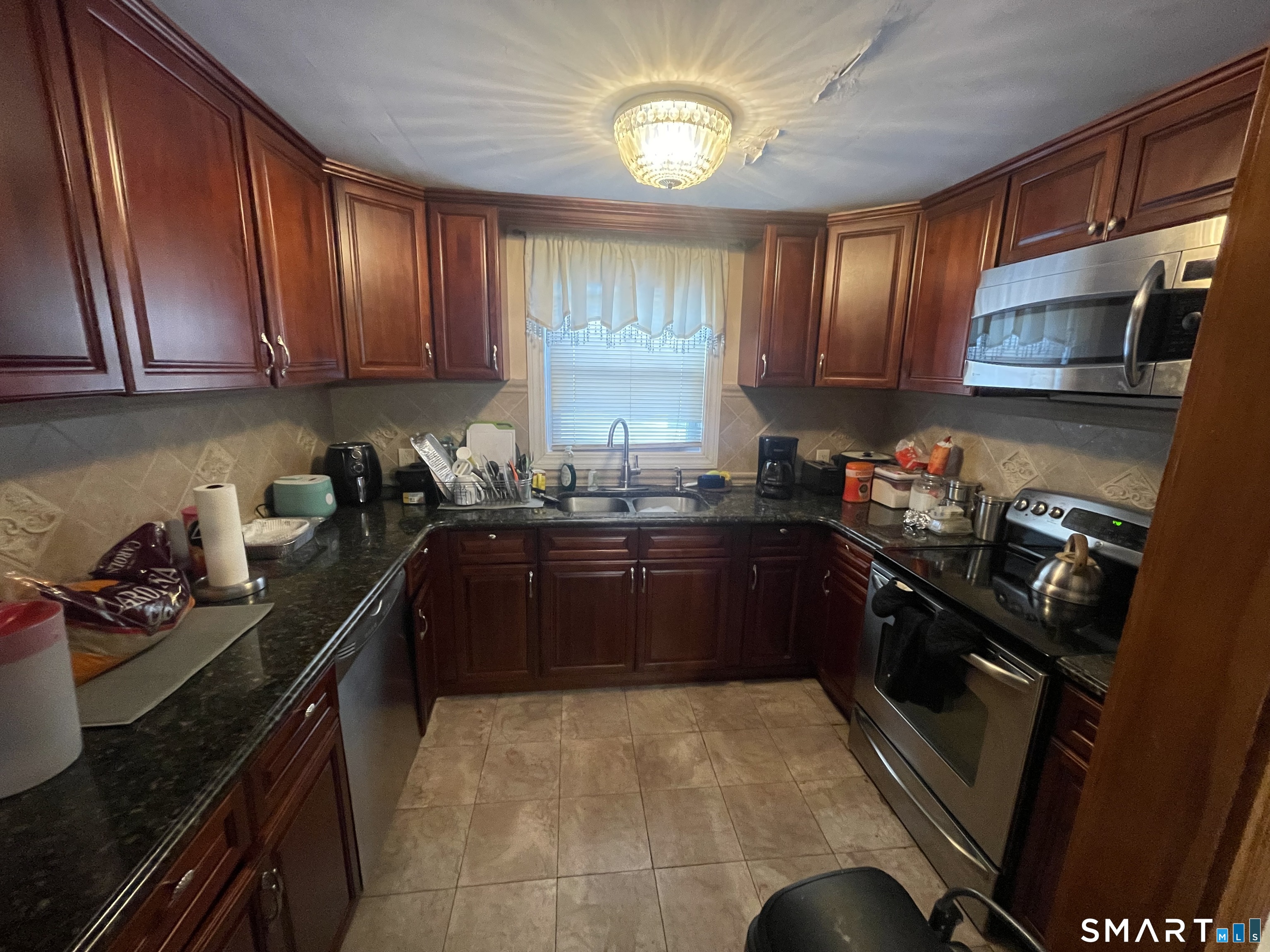 52 Bennett Avenue Waterbury, CT 06708 - Photo 16 of 36 a kitchen with granite countertop a stove sink and cabinets