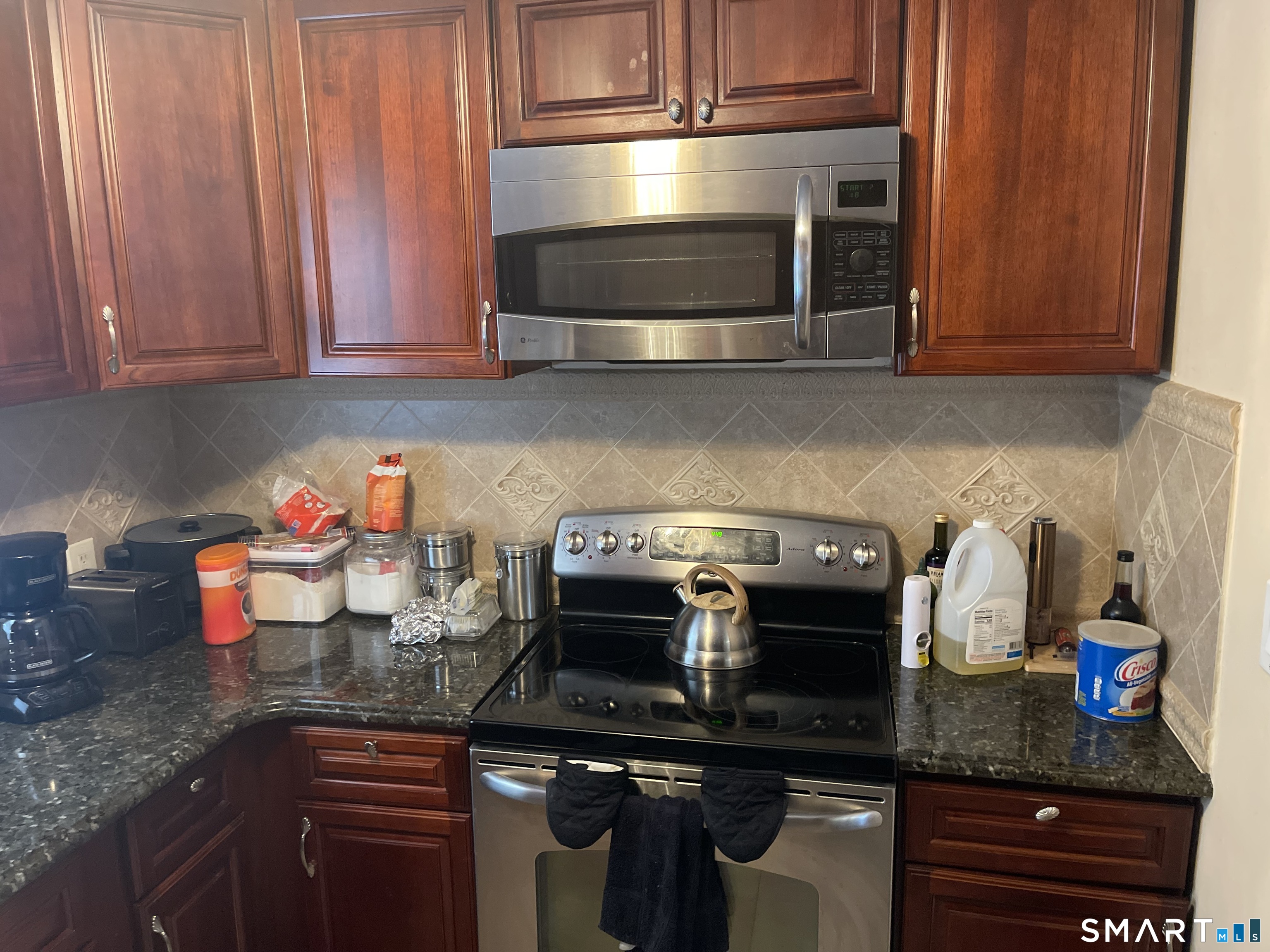 52 Bennett Avenue Waterbury, CT 06708 - Photo 20 of 36 a kitchen with stainless steel appliances granite countertop a stove a microwave and cabinets