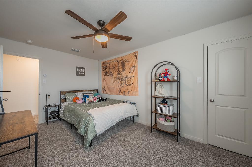 8125 White Sulphur Road Ponder, TX 76259 - Photo 28 of 38 Spacious room featuring neutral paint, gray carpet, a ceiling fan with light fixture, and a white arched panel door