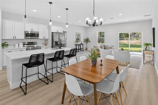 a view of a dining room with furniture a chandelier and wooden floor