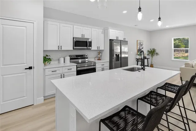 a kitchen with stainless steel appliances a table and chairs in it