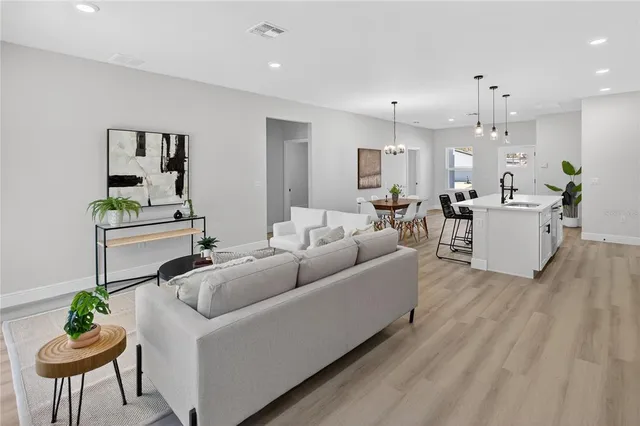 a living room with furniture a chandelier and a dining room
