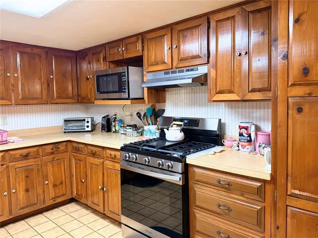 a kitchen with stainless steel appliances granite countertop a stove and cabinets