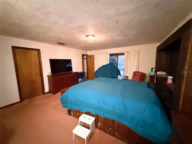 a bedroom with a bed and a television