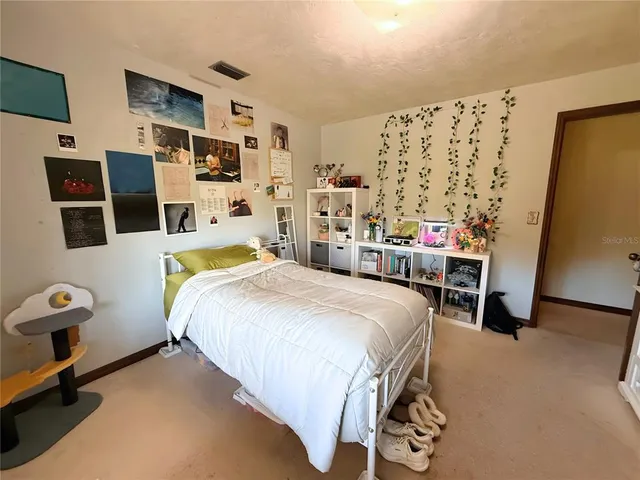 a bedroom with a bed a flat screen tv and dresser