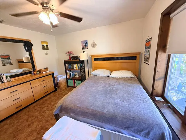 a bedroom with a bed and a flat tv screen on dresser