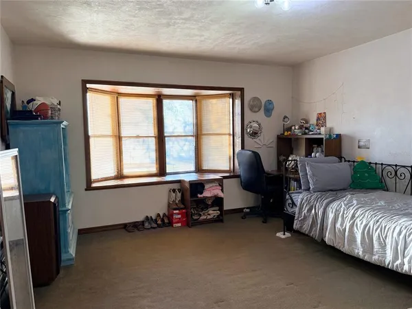 a spacious bedroom with a bed couch and a window