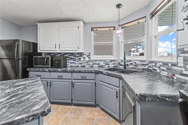 a kitchen with kitchen island granite countertop wooden cabinets and a refrigerator