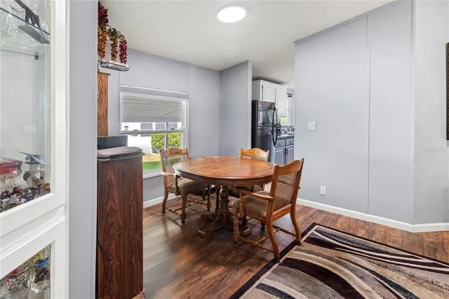 a view of a hallway with wooden floor and a living room