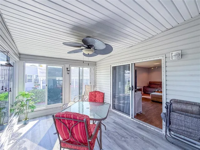 a view of a large body of water with lawn chairs under an umbrella with large trees