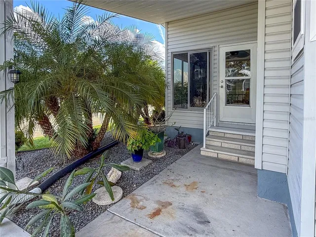 a view of a patio with table and chairs and a barbeque