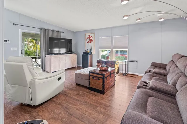 a living room with furniture ceiling fan and a flat screen tv