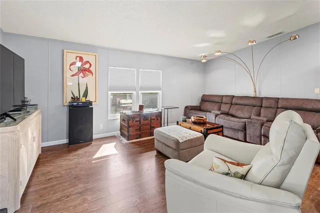 a kitchen with stainless steel appliances granite countertop a stove top oven a refrigerator a sink and white cabinets