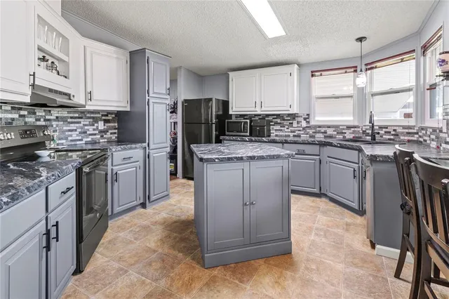 a kitchen with stainless steel appliances granite countertop a stove and a refrigerator