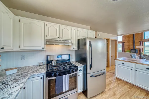a kitchen with stainless steel appliances granite countertop a stove a refrigerator and a granite counter tops