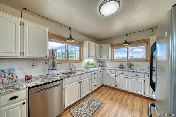 a kitchen with granite countertop a sink stainless steel appliances and cabinets