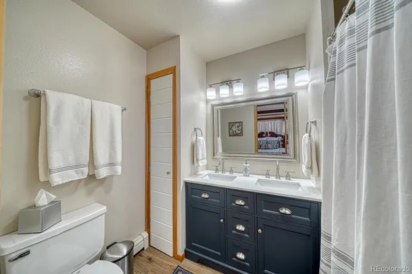 a bathroom with a double vanity sink mirror and toilet