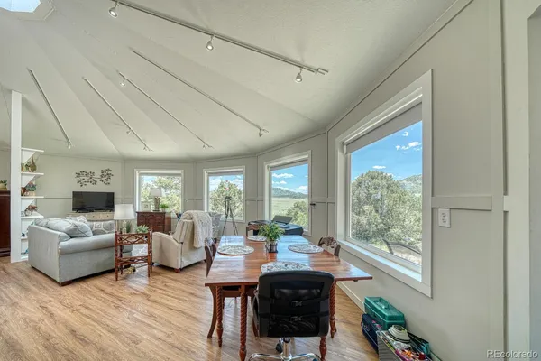 a living room with furniture flat screen tv and a large window