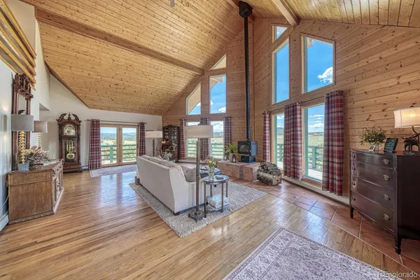 a living room with furniture a wooden floor and next to a window