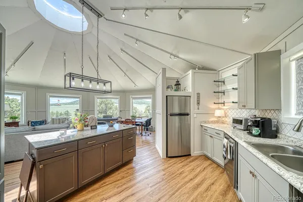 a kitchen with a sink and wooden floor