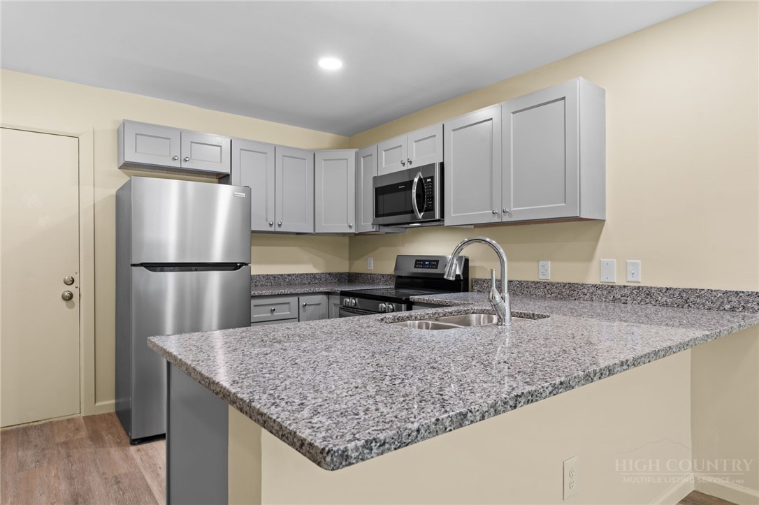128 Zeb Street, Unit A104 Boone, NC 28607 - Photo 8 of 35 a kitchen with stainless steel appliances granite countertop a sink stove and refrigerator