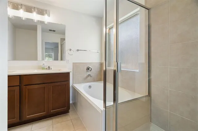 a bathroom with a tub sink and mirror