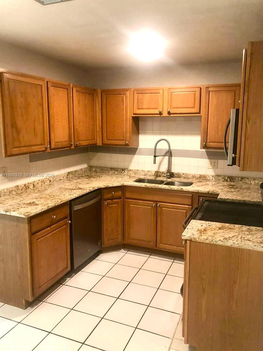 580 Tallulah Road Lake Worth, FL 33462 - Photo 6 of 12 a kitchen with stainless steel appliances granite countertop a sink stove and cabinets