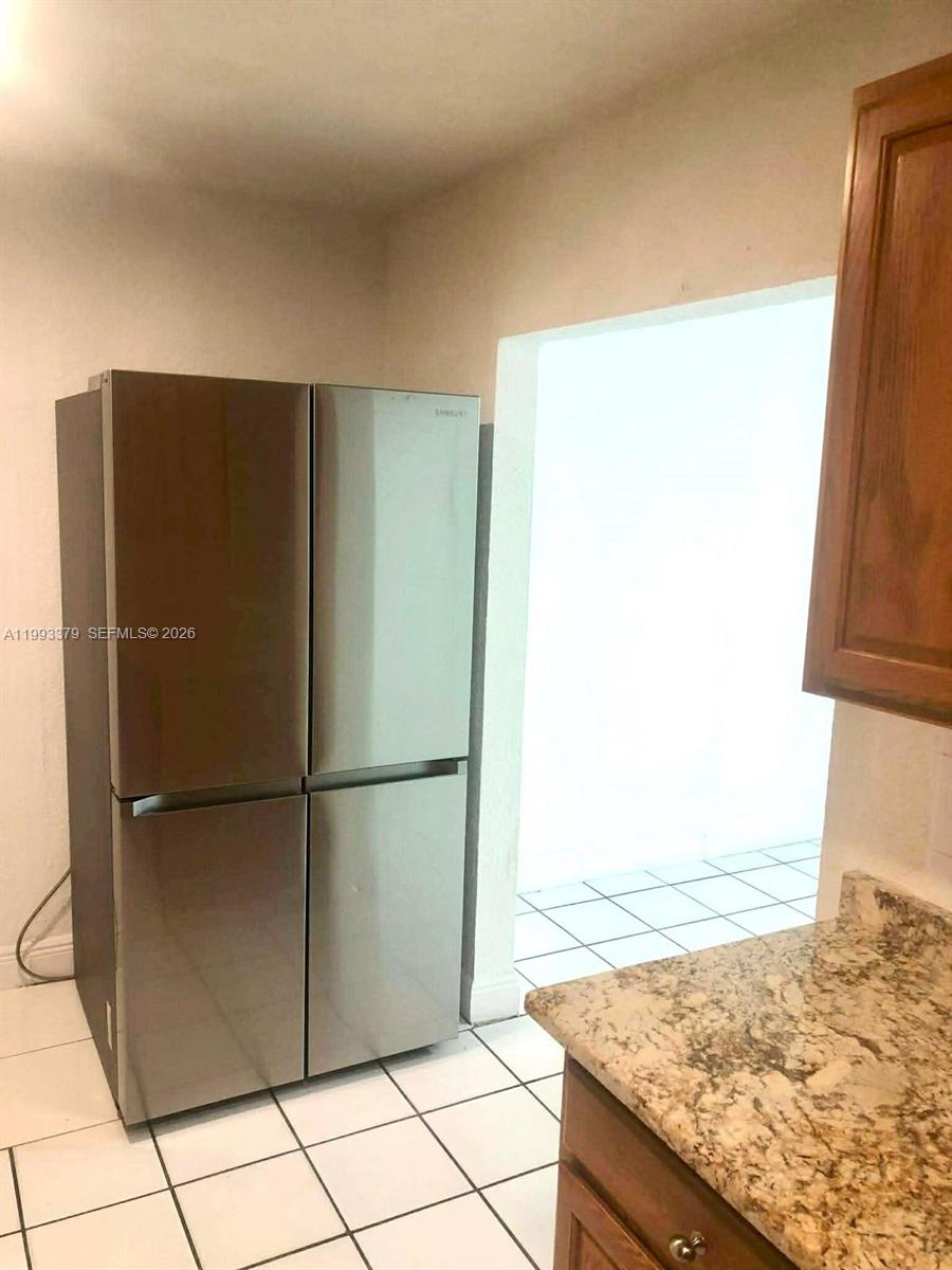 580 Tallulah Road Lake Worth, FL 33462 - Photo 8 of 12 a view of a refrigerator in kitchen and an empty room
